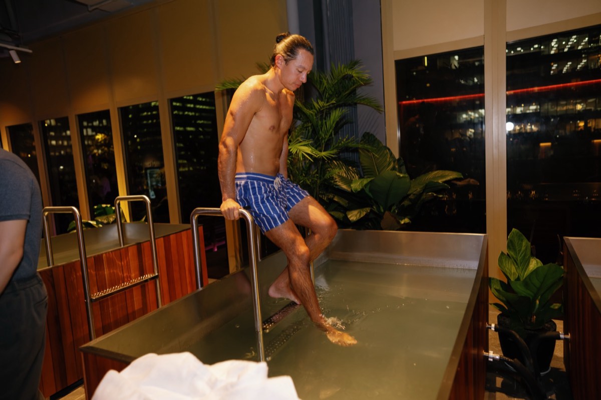 Guest stepping into the cold plunge at night